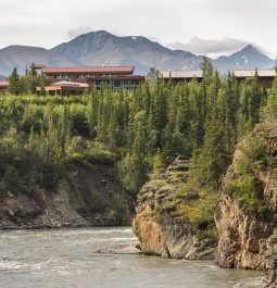 river canyon with lodge and mountains in the background