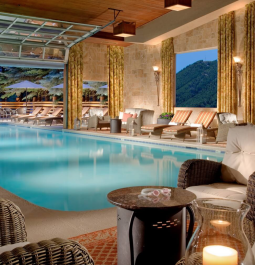 indoor swimming pool with garage door that opens up to outdoor patio