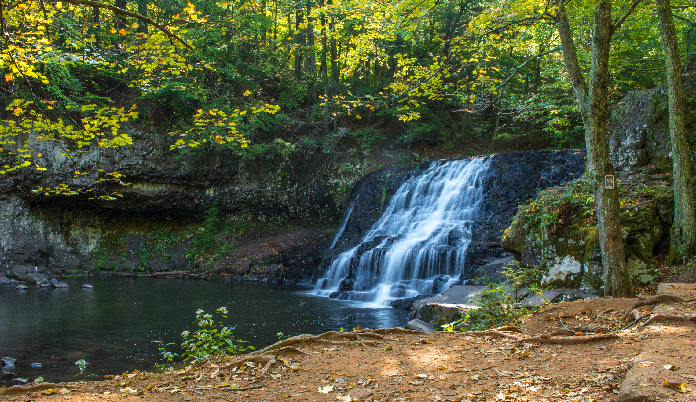 Wadsworth Falls surrounded by trees in Middlefield, Connecticut in early autumn