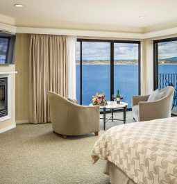 Hotel room with panoramic windows overlooking the ocean and a fireplace