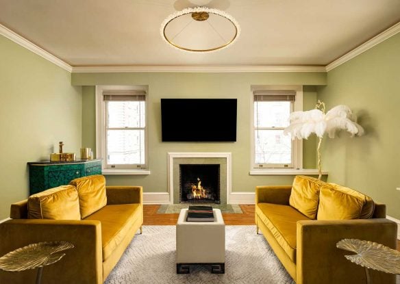 living room with two yellow couches facing each other and a fireplace