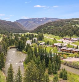 aerial view of riverside lodge surrounded by mountains