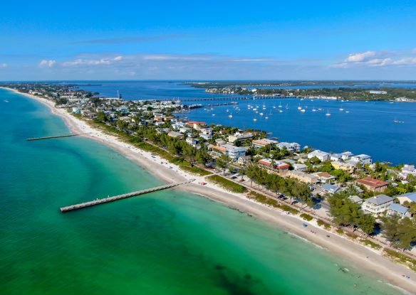 Aerial view of Cortez beach withe sand beach and his little wood pier on blue water, Anna Maria Island, Florida, USA