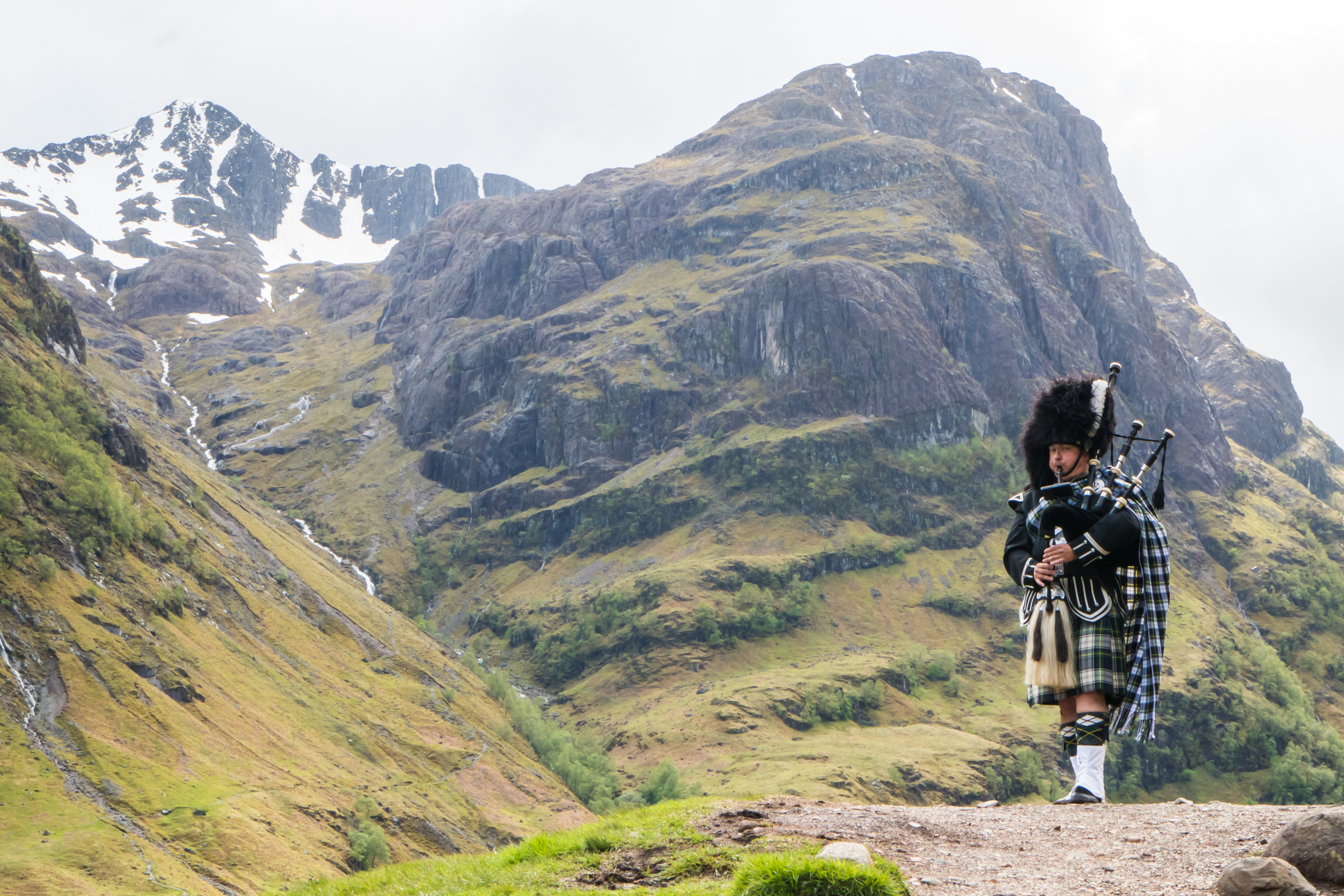 Traditional bagpiper in the Scottish highlands